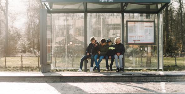 kinderen wachten op de bus