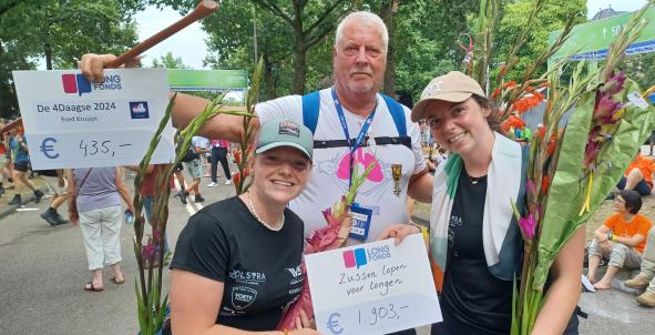 Twee vrouwen en een man houden een cheque van Longfonds vast tijdens Nijmeegse Vierdaagse
