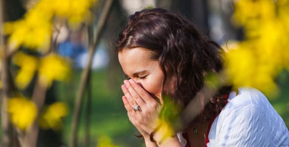 Vrouw niest door hooikoorts