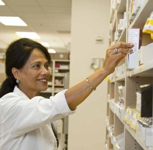 Vrouw pakt medicijnen in apotheek
