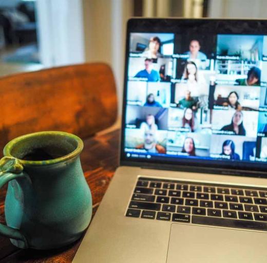 Kop koffie naast een laptop waar een online evenement gaande is