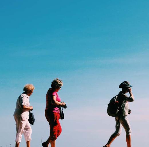 Drie vrouwen wandelen tegen een achtergrond van blauwe lucht