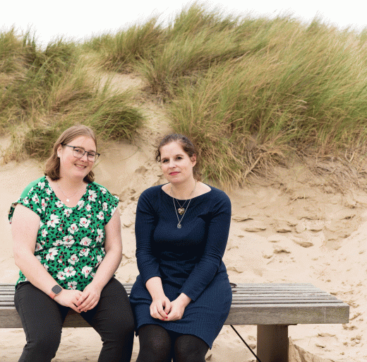 Anique en Marion op een bankje op het strand