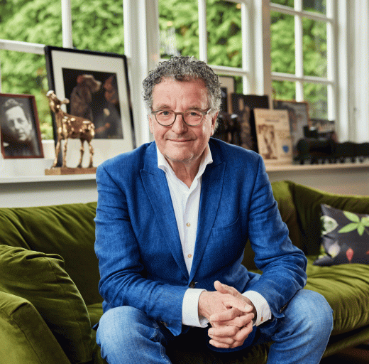 Edwin de Vries op de bank in zijn woonkamer, een Gouden Kalf op de achtergrond