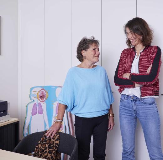 Ellie en praktijkondersteuner Merel kijken naar elkaar in de behandelkamer