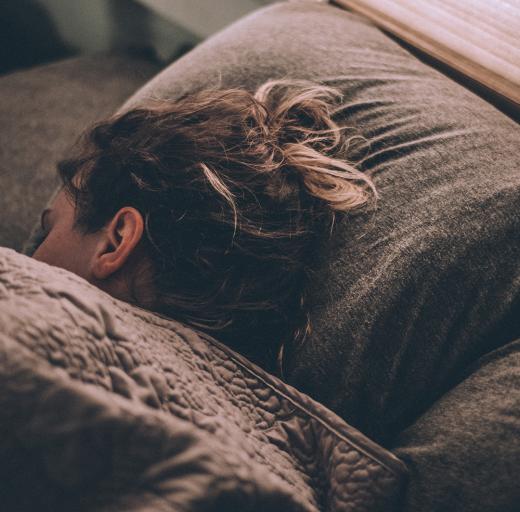 Slapende vrouw met haar hoofd op een kussen