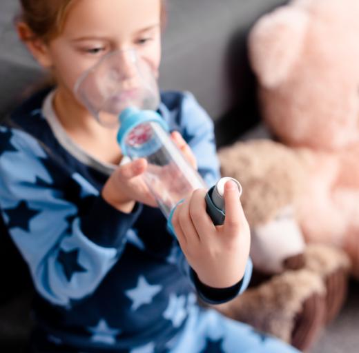 Een jongetje inhaleert medicijnen met een puffer met voorzetkamer