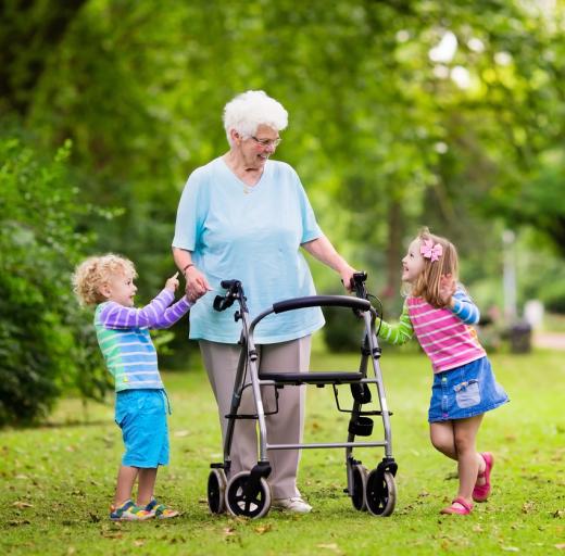 Vrouw met rollator in het park met kleinkinderen