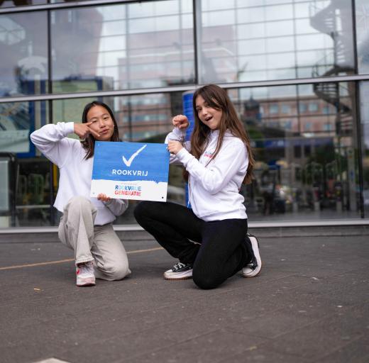 Meiden met rookvrij bordje in Amersfoort op stationsplein