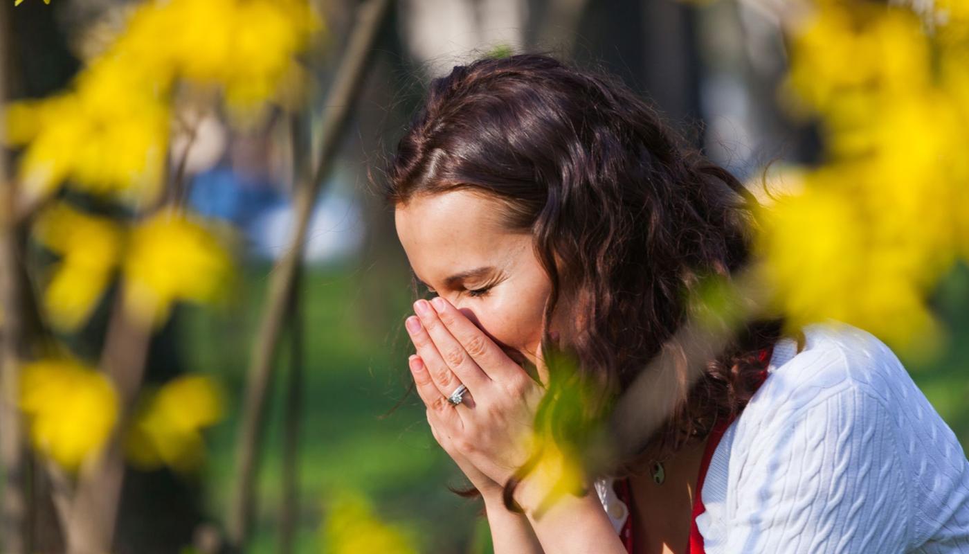 Vrouw niest door hooikoorts