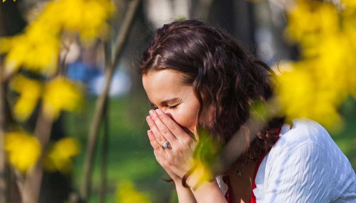 Vrouw niest door hooikoorts