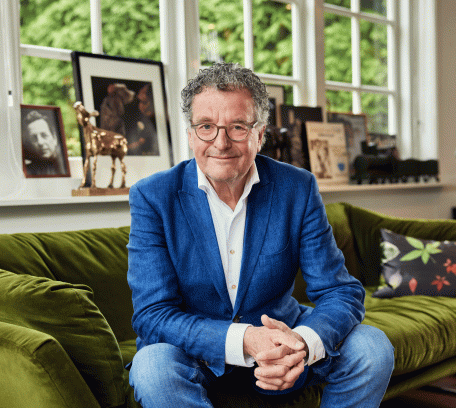 Edwin de Vries op de bank in zijn woonkamer, een Gouden Kalf op de achtergrond