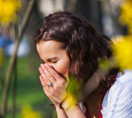 Vrouw niest door hooikoorts
