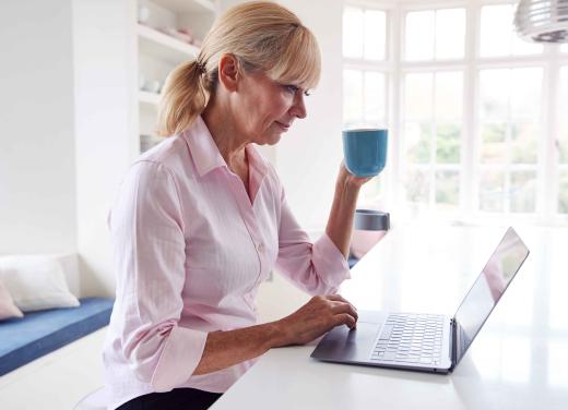 Digitale koffietafel, dame met mok koffie achter een laptop