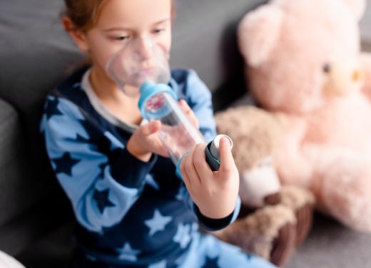 Een jongetje inhaleert medicijnen met een puffer met voorzetkamer