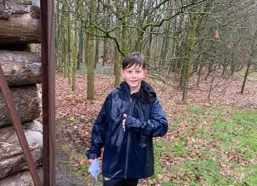 Jongetje in regenjas doet duim omhoog