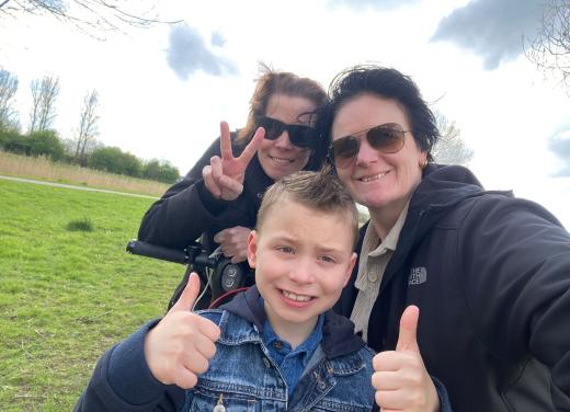 Gezin lacht, terwijl zoon met duimpjes omhoog staat