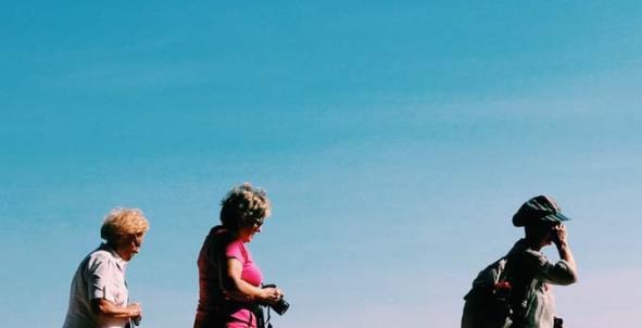 Drie vrouwen wandelen tegen een achtergrond van blauwe lucht