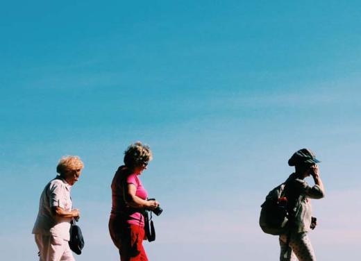 Drie vrouwen wandelen tegen een achtergrond van blauwe lucht